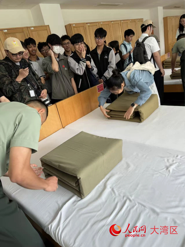 图为同学们认真模仿学习叠被子。人民网记者 富子梅摄